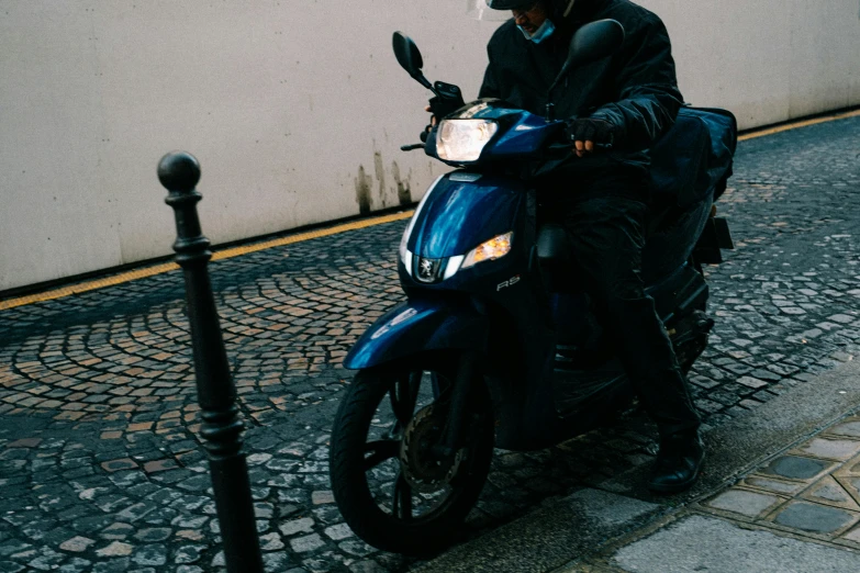 a man riding a motorcycle down a cobblestone street, pexels contest winner, dark blue, in paris, slightly pixelated, moped