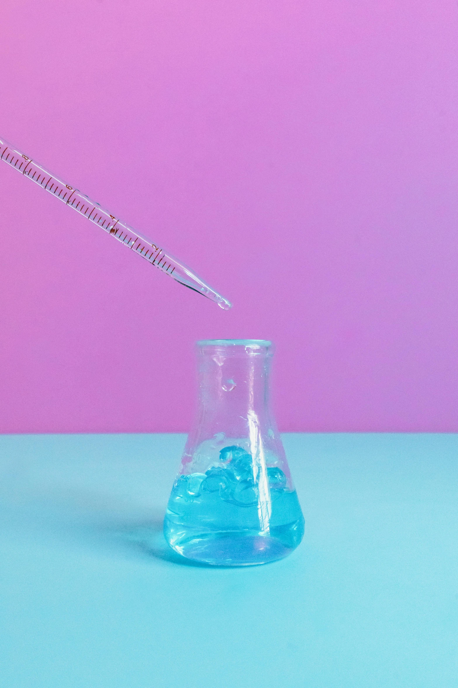 a glass beaker filled with blue liquid on a pink and blue background, an album cover, trending on pexels, holding syringe, engineering, hey, gen z