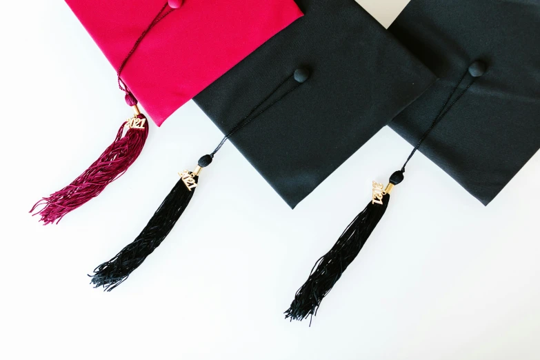 a close up of a graduation cap and tassel, unsplash, academic art, black and red silk clothing, set against a white background, various styles, maroon