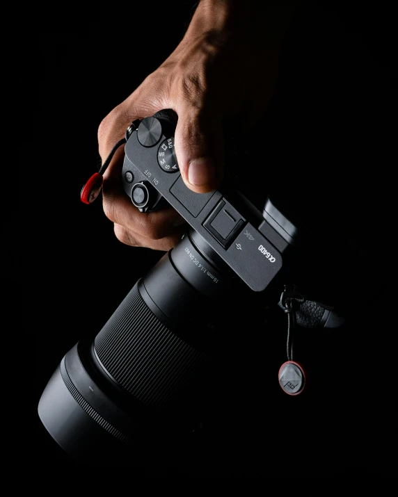 a person holding a camera in their hand, red on black, detailed product image, large)}], action shot