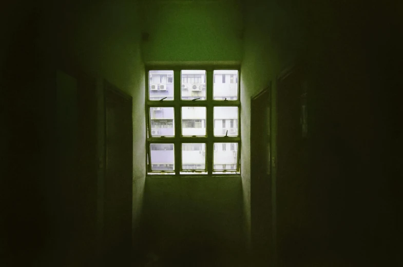 a green light shines through a window in a dark room, an album cover, inspired by Elsa Bleda, bo xun ling, alleys, prison, analogue photo