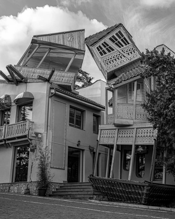 a black and white photo of an upside down house, by Kristian Kreković, unsplash contest winner, surrealism, fallout style istanbul, wooden houses, huge smashed mansion, built on a steep hill