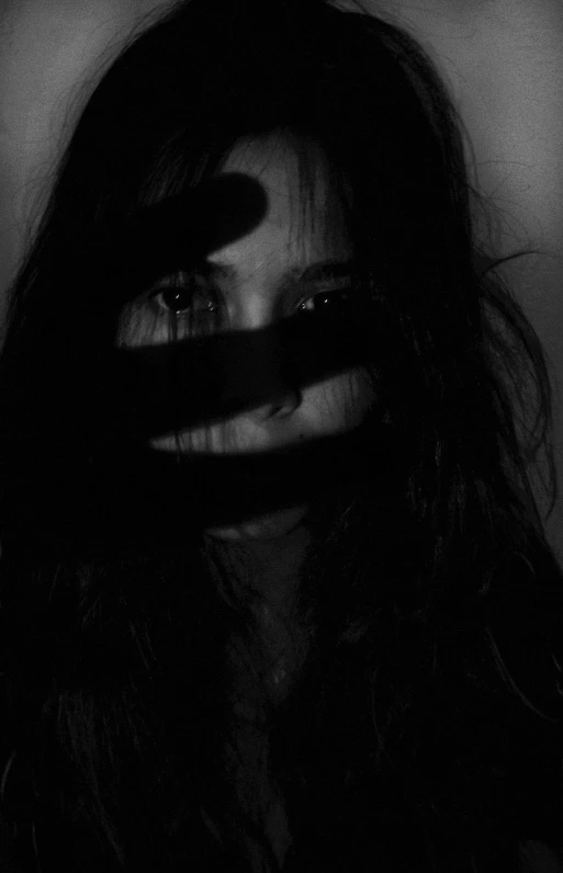 a black and white photo of a woman with long hair, inspired by Kati Horna, tumblr, dark visor covering face, scarred face, (((((((no glow))))))), hiding