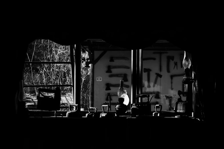 a black and white photo of a person on a stage, by Mathias Kollros, unsplash, graffiti, window. netherlands tavern, hard morning light, sat down in train aile, dusty abandoned shinjuku
