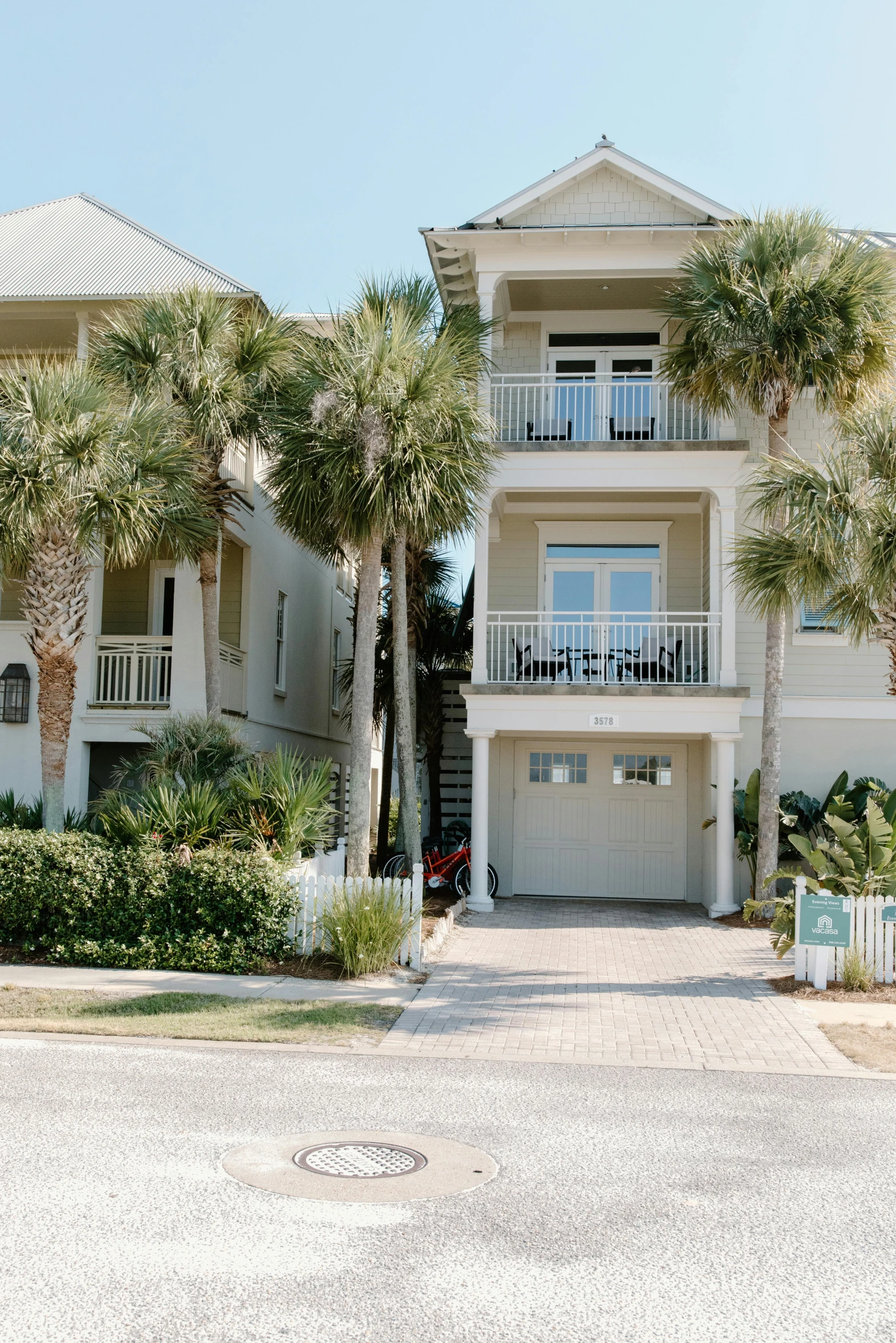 a house with palm trees in front of it, by Lynn Pauley, unsplash, the emerald coast, street elevation, wide high angle view, large staircase