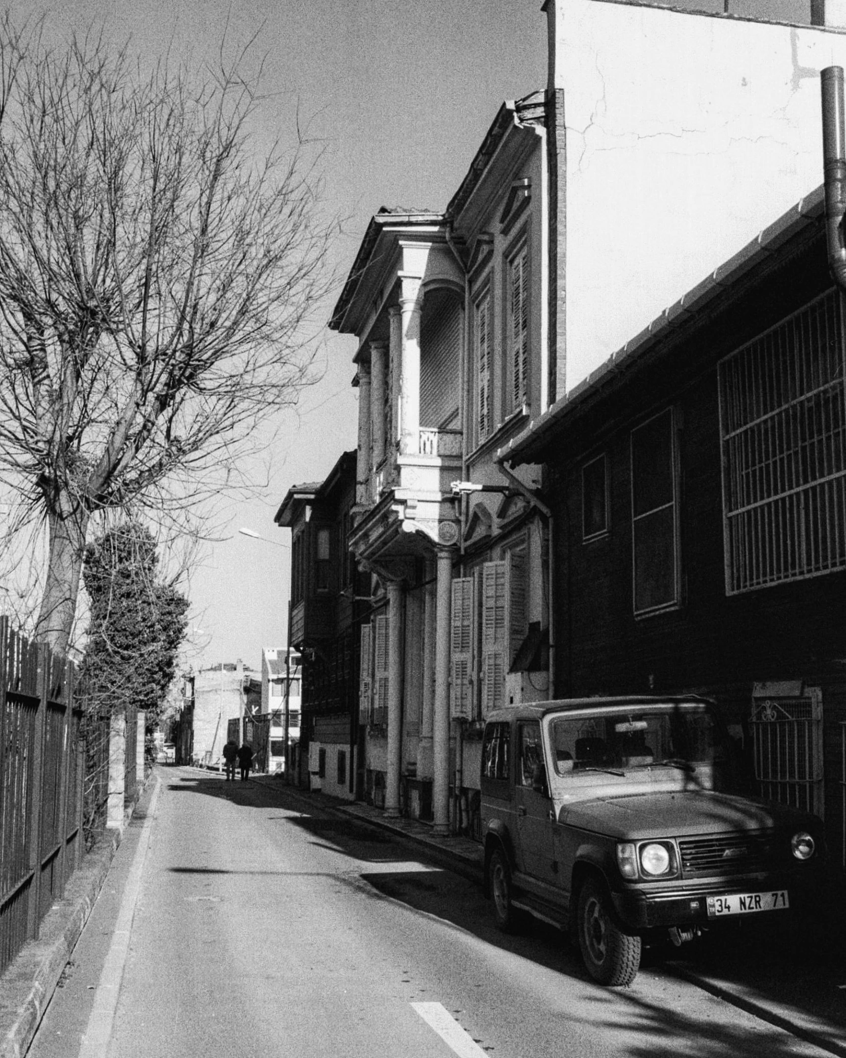 a truck parked on the side of a street, a black and white photo, by Niyazi Selimoglu, ashcan school, 1 7 0 0 s, single building, 1999 photograph, prefecture streets