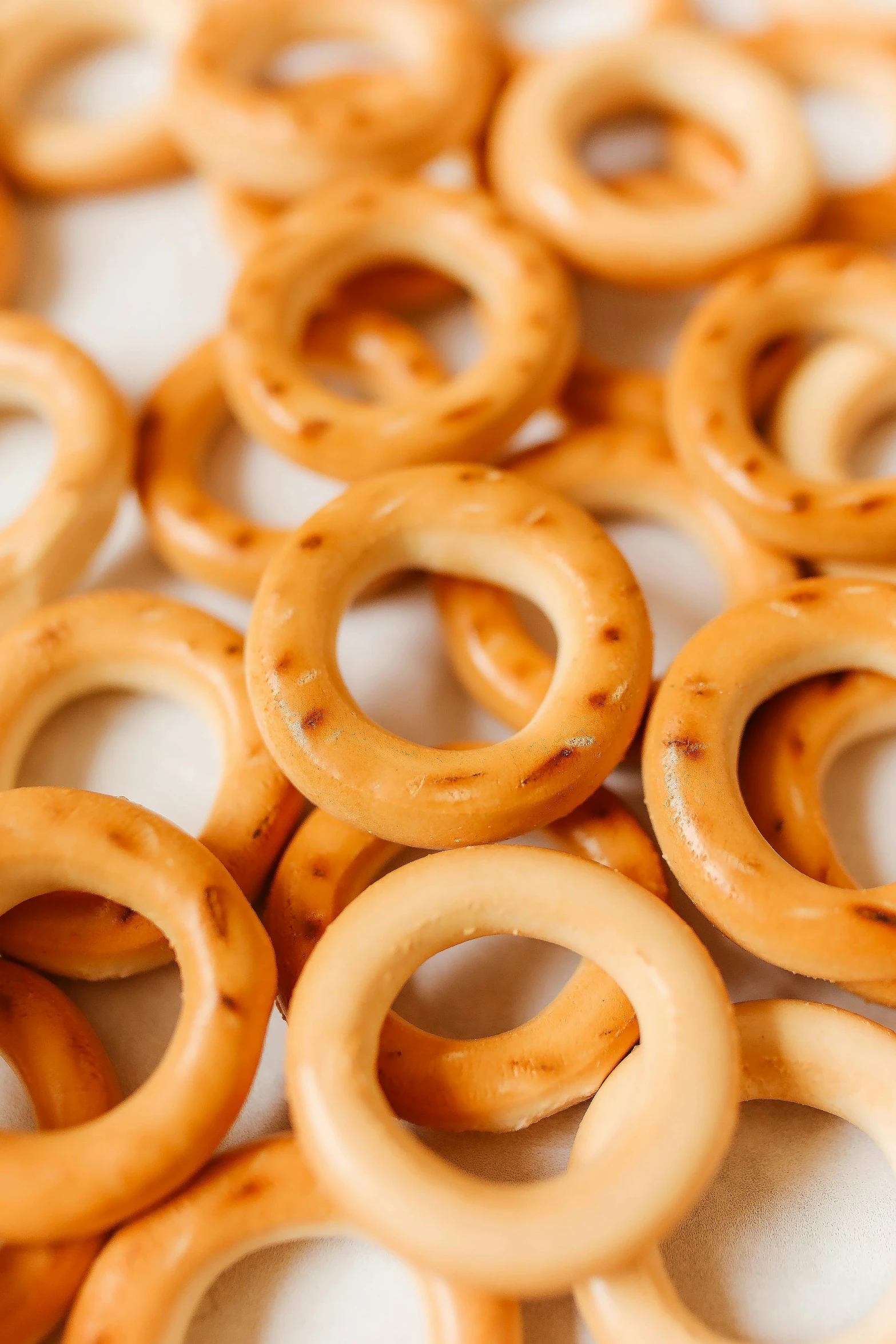 a pile of wooden rings sitting on top of a table, snacks, cheesy, subtle pattern, manuka