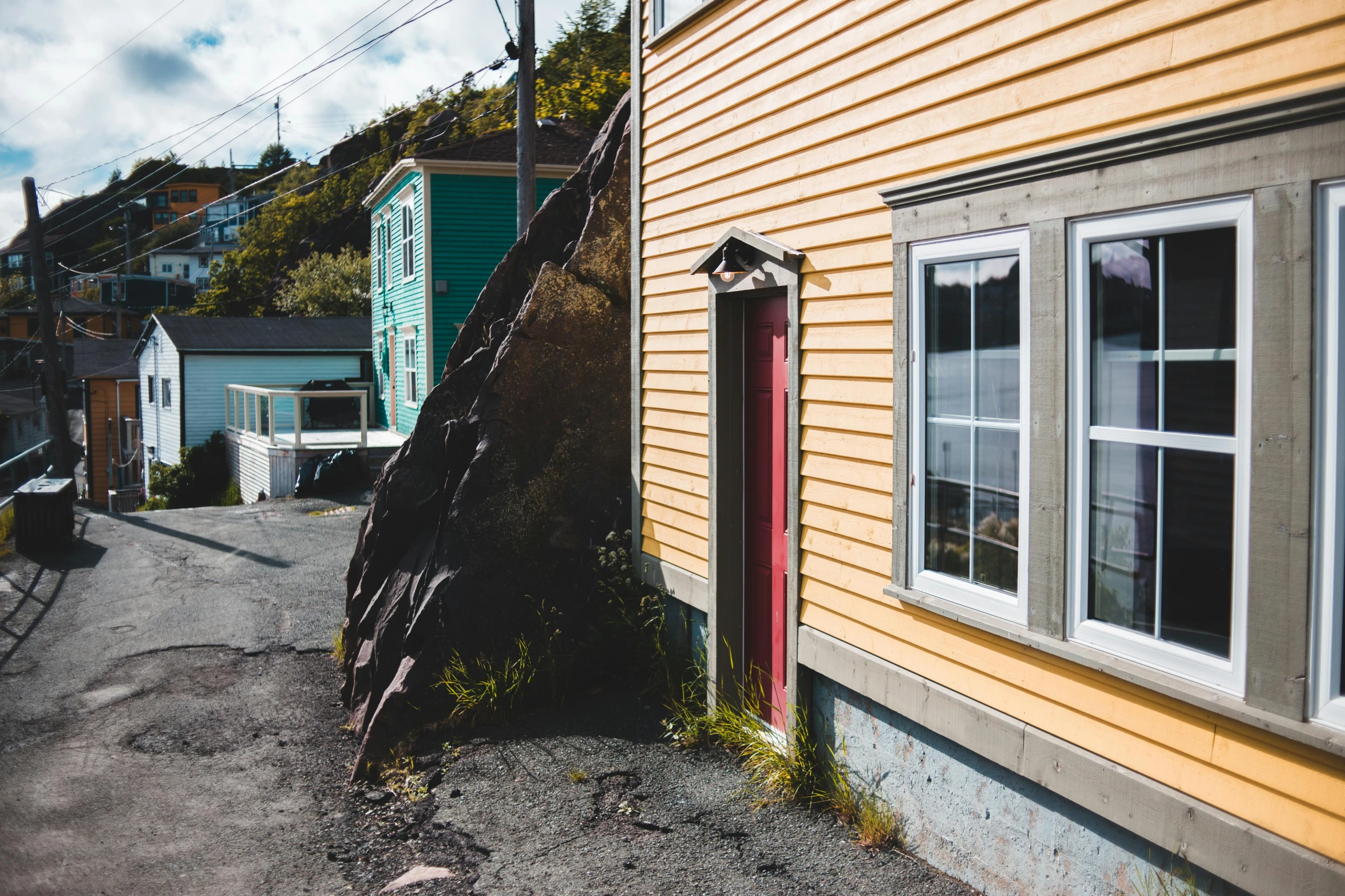 a ladder leaning against the side of a house, a photo, by Carey Morris, pexels contest winner, hyperrealism, cliffside town, gauthier leblanc, on the side of the road, durty colours