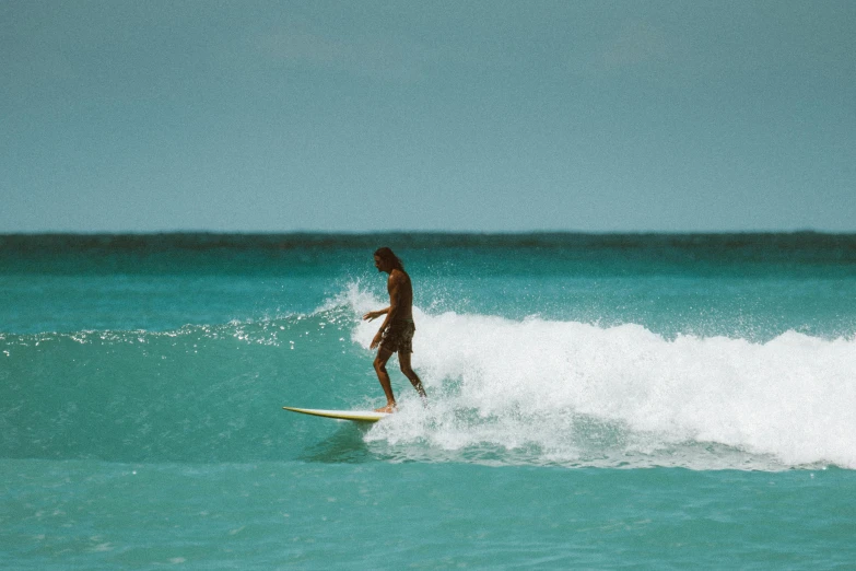 a man riding a wave on top of a surfboard, pexels contest winner, aruba, slightly tanned, profile image, malaysian