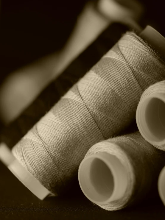 three spools of thread sitting next to each other, a picture, by Thomas Häfner, sepia, high quality product image”, cotton fabric, small manufacture