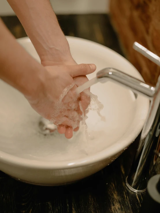 a person washing their hands in a bowl, by Julia Pishtar, pexels, 15081959 21121991 01012000 4k, full-body, close to night, soap carving