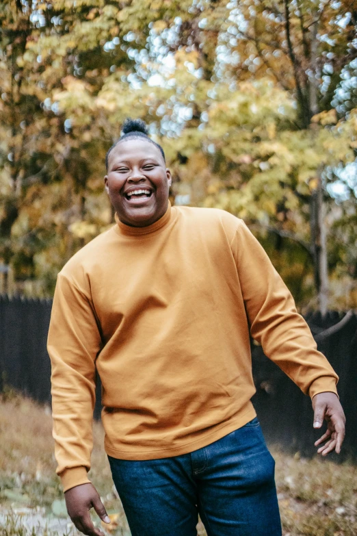 a man that is standing in the grass, trending on unsplash, happening, plus size woman, brown sweater, happy and smiling, obunga