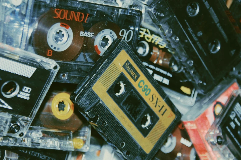 a pile of audio cassettes stacked on top of each other, inspired by Elsa Bleda, trending on pexels, sovietwave aesthetic, old photo scattered, various items, 1 9 8 0 s style