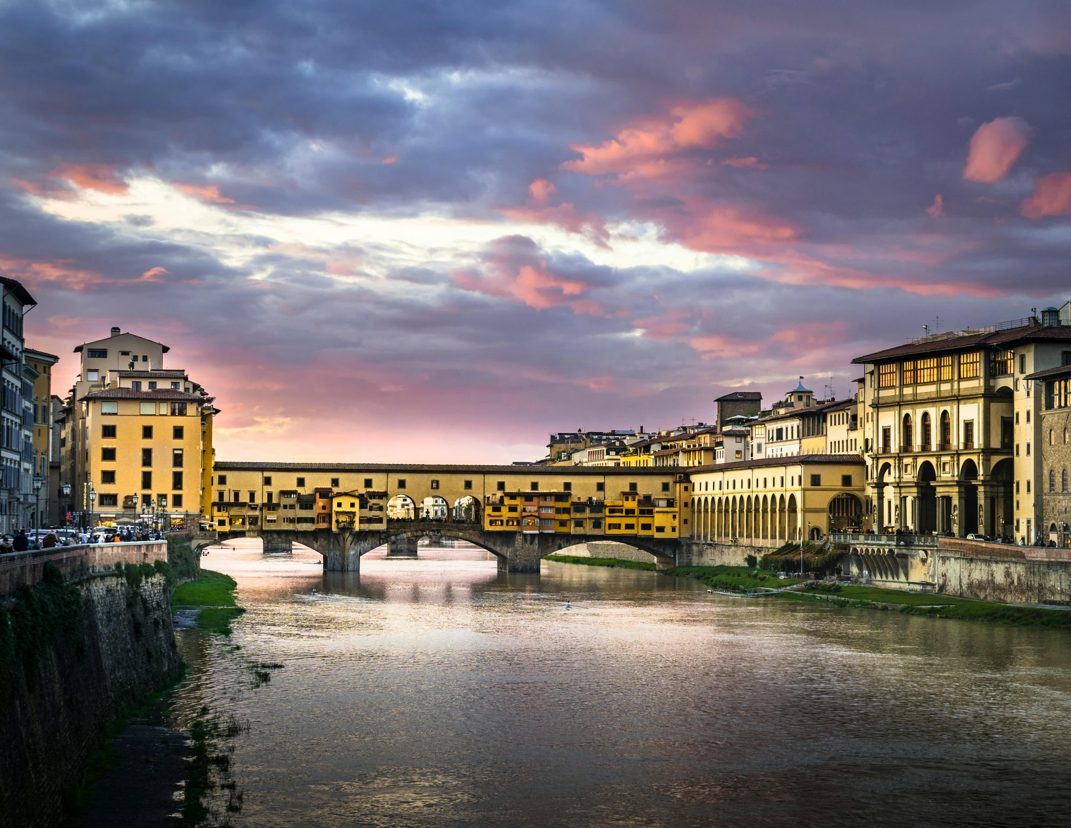 a river running through a city next to tall buildings, inspired by Michelangelo Buonarotti, pexels contest winner, renaissance, square, florence, violet and yellow sunset, brown