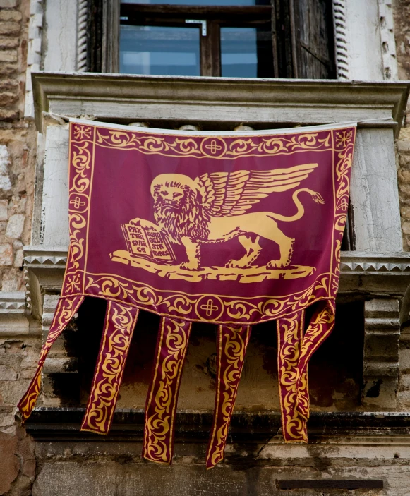 a red and gold banner hanging from the side of a building, renaissance, burnt sienna and venetian red, lion's gate, city views, square