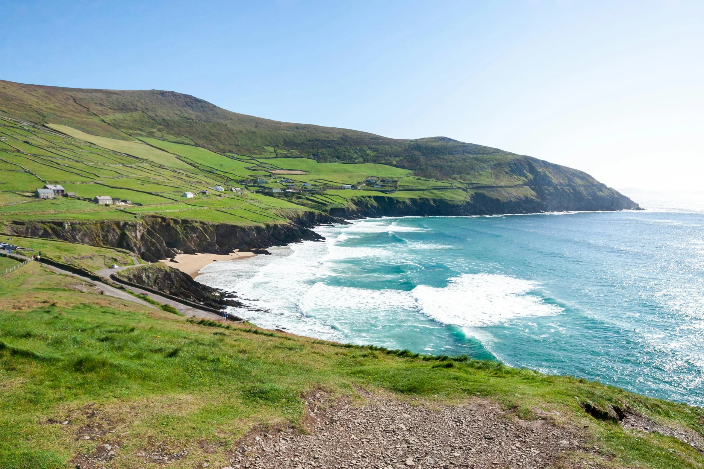 a large body of water next to a lush green hillside, inspired by Mór Than, pexels contest winner, beach is between the two valleys, 🚿🗝📝