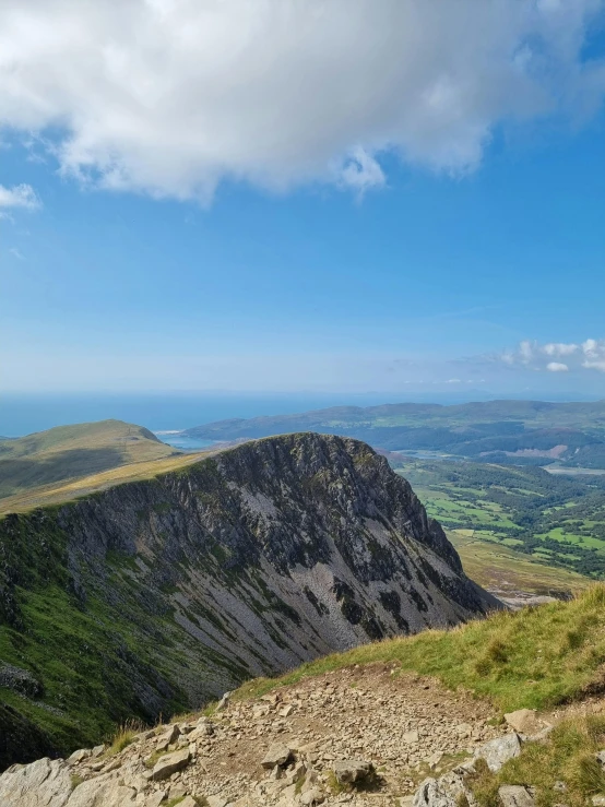 a group of people standing on top of a mountain, by Bedwyr Williams, pexels contest winner, les nabis, hills and ocean, slate, two mountains in background, thumbnail