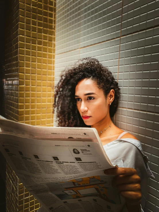 a woman reading a newspaper in a bathroom, by Julia Pishtar, pexels contest winner, happening, mixed race woman, portrait of zendaya, promo image, young middle eastern woman