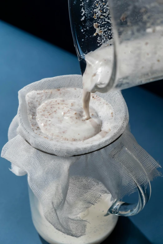 a pitcher filled with liquid sitting on top of a table, made of lab tissue, cement, yogurt, thumbnail