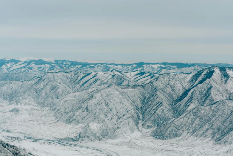 a man riding a snowboard on top of a snow covered slope, an album cover, inspired by Andreas Gursky, pexels contest winner, hurufiyya, near lake baikal, view from helicopter, photo of genghis khan, detailed terrain