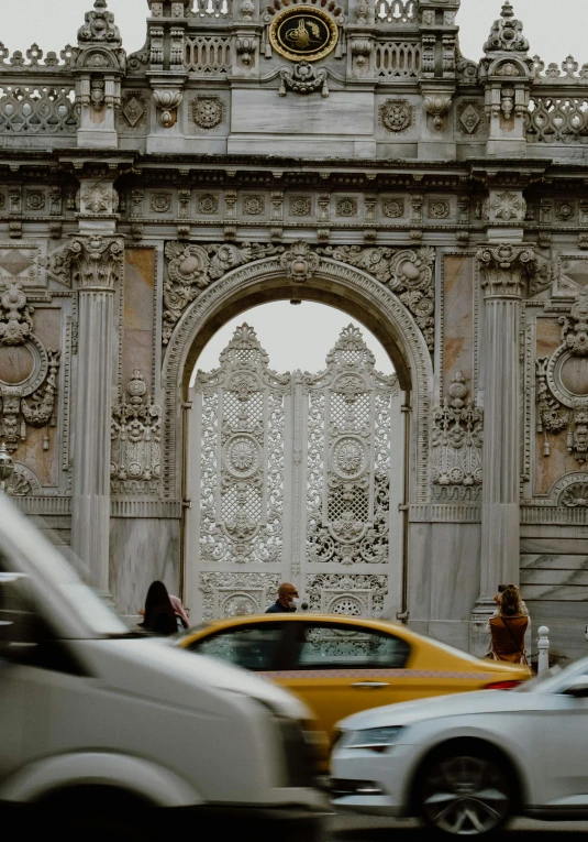 a couple of cars that are sitting in front of a gate, by Niyazi Selimoglu, pexels contest winner, baroque, carved white marble, people walking around, louis sullivan, fallout style istanbul