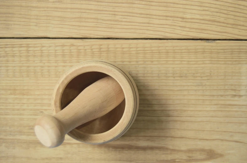 a wooden mortar brush sitting on top of a wooden table, inspired by Agnes Martin, unsplash, pointè pose, natural dull colours, kitchen background, smooth panelling