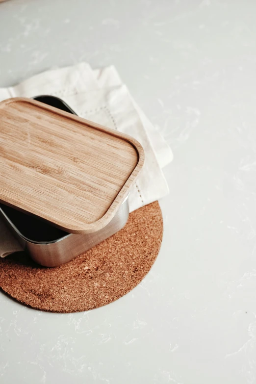 a wooden tray sitting on top of a white table, by Eden Box, unsplash, metal lid, eats bambus, steel, garbage