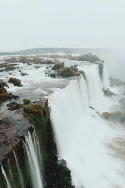 a man standing on the edge of a waterfall, buenos aires, misty weather, more intense, whale fall