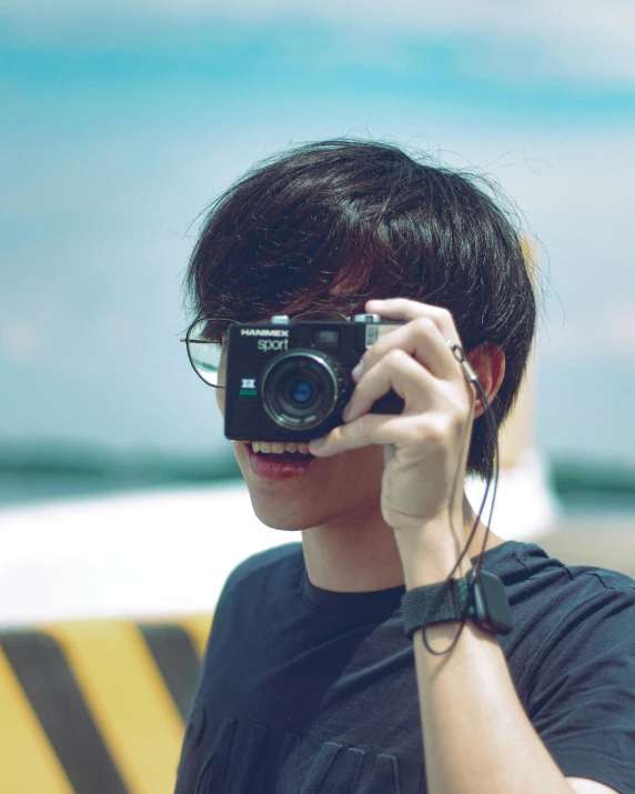 a person taking a picture with a camera, boy has short black hair, non-binary, overexposed photograph, asian male