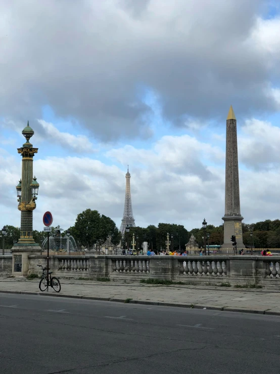 a person riding a bike across a bridge, neoclassicism, glass obelisks, on loan from louvre, 8k ”