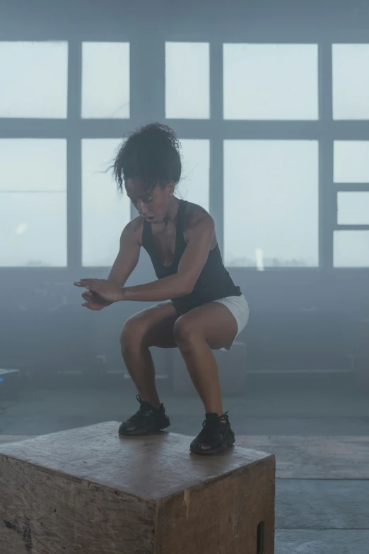 a woman sitting on top of a wooden box, sweat flying, in a gym, ashteroth, highly turbulent