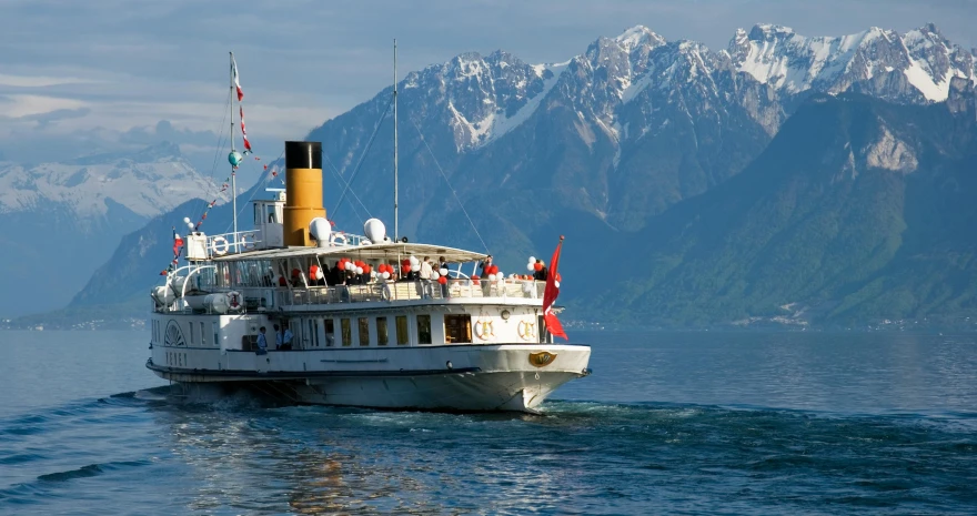 a boat on a body of water with mountains in the background, by Julia Pishtar, pexels contest winner, art nouveau, swiss, slim aarons, queen elizabeth, everyone having fun