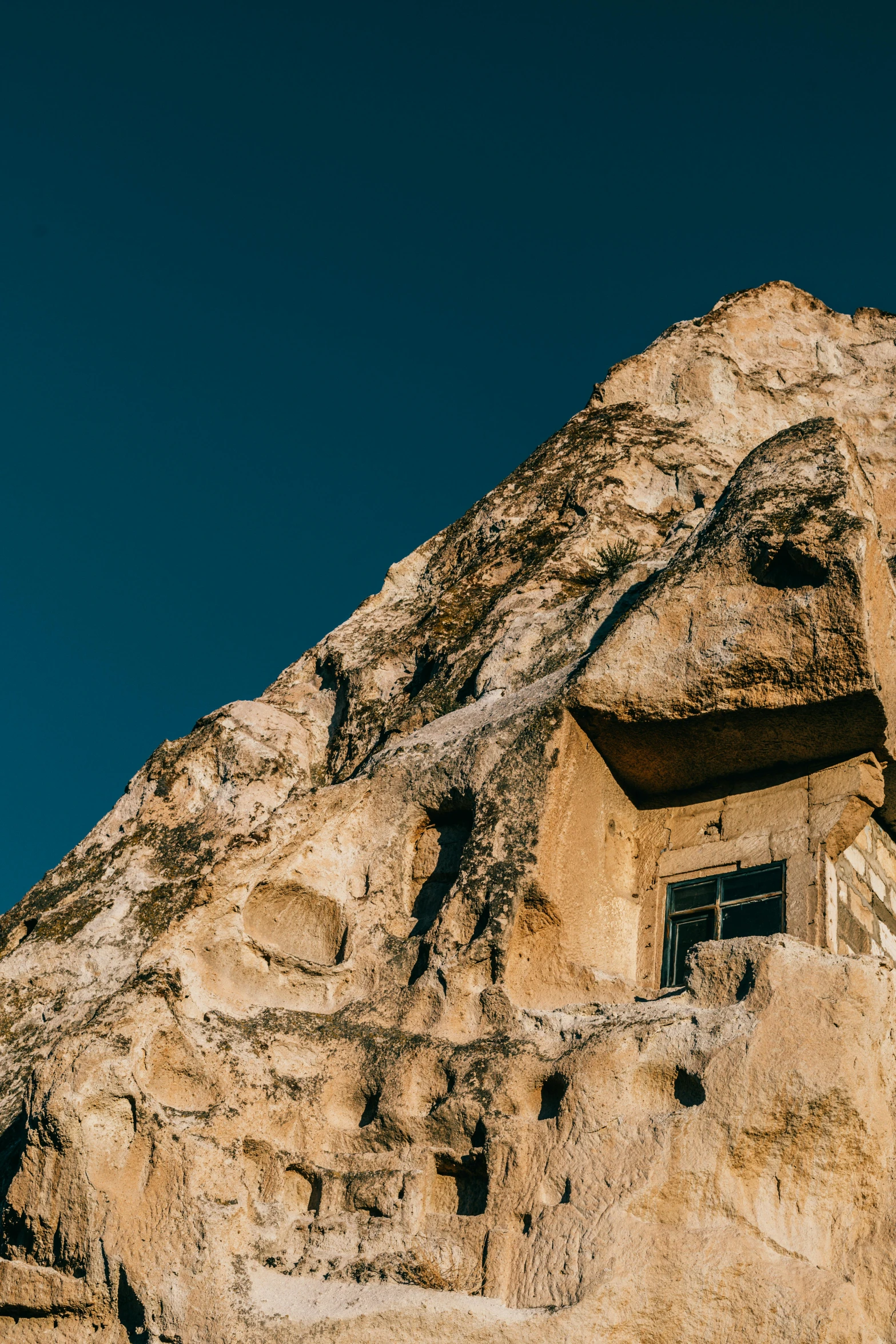 a building built into the side of a mountain, a cave painting, trending on unsplash, art nouveau, turkey, multiple stories, conde nast traveler photo, made of stone and concrete