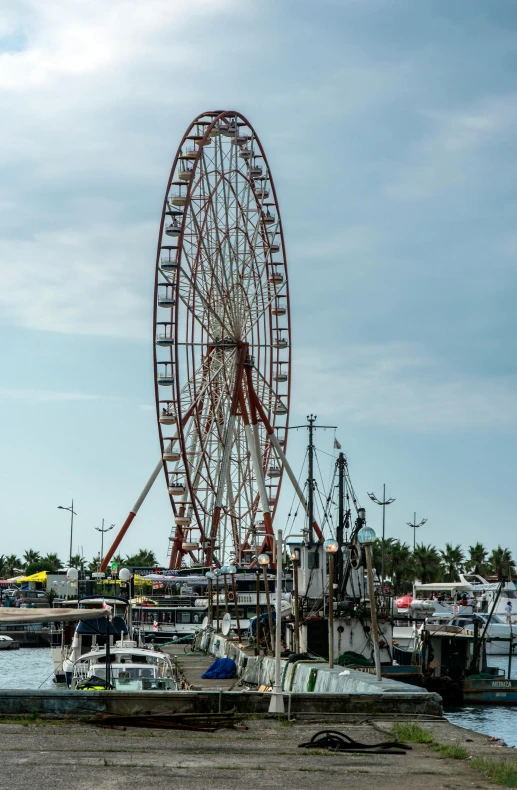 a ferris wheel sitting next to a body of water, by Dave Melvin, hurufiyya, ships in the harbor, manila, iso 1 0 0 wide view, closeup - view