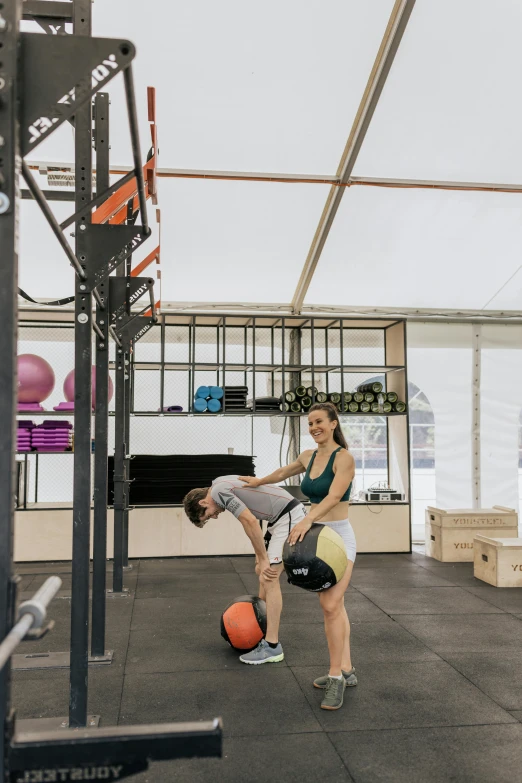 a couple of people that are playing with a ball, local gym, julia hetta, high-quality photo, fit build