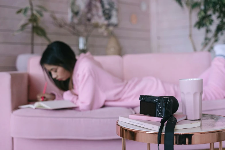 a woman laying on a couch reading a book, a picture, pexels contest winner, happening, pink clothes, sony camera, gemma chen, diary on her hand