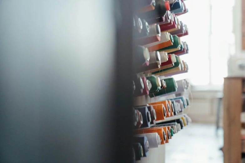 a close up of a bunch of toothbrushes on a wall, by Emma Andijewska, unsplash, blurry background of the library, shot on hasselblad, ribbons, paint tubes