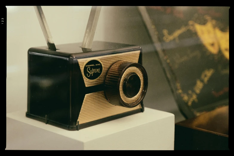 a black and gold radio sitting on top of a table, unsplash, video art, photo taken on an old box camera, on display in a museum, sigma 55”, footage from space camera