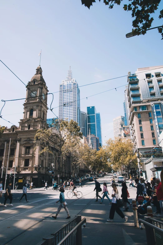 a group of people walking across a street next to tall buildings, inspired by Sydney Carline, trending on unsplash, renaissance, north melbourne street, on a great neoclassical square, daytime, christian saint