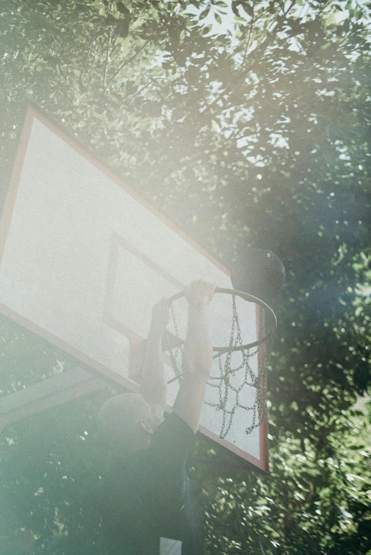 a man standing next to a basketball hoop, inspired by Elsa Bleda, pexels contest winner, movie frame still, sunfaded, flying shot, ( ( theatrical ) )