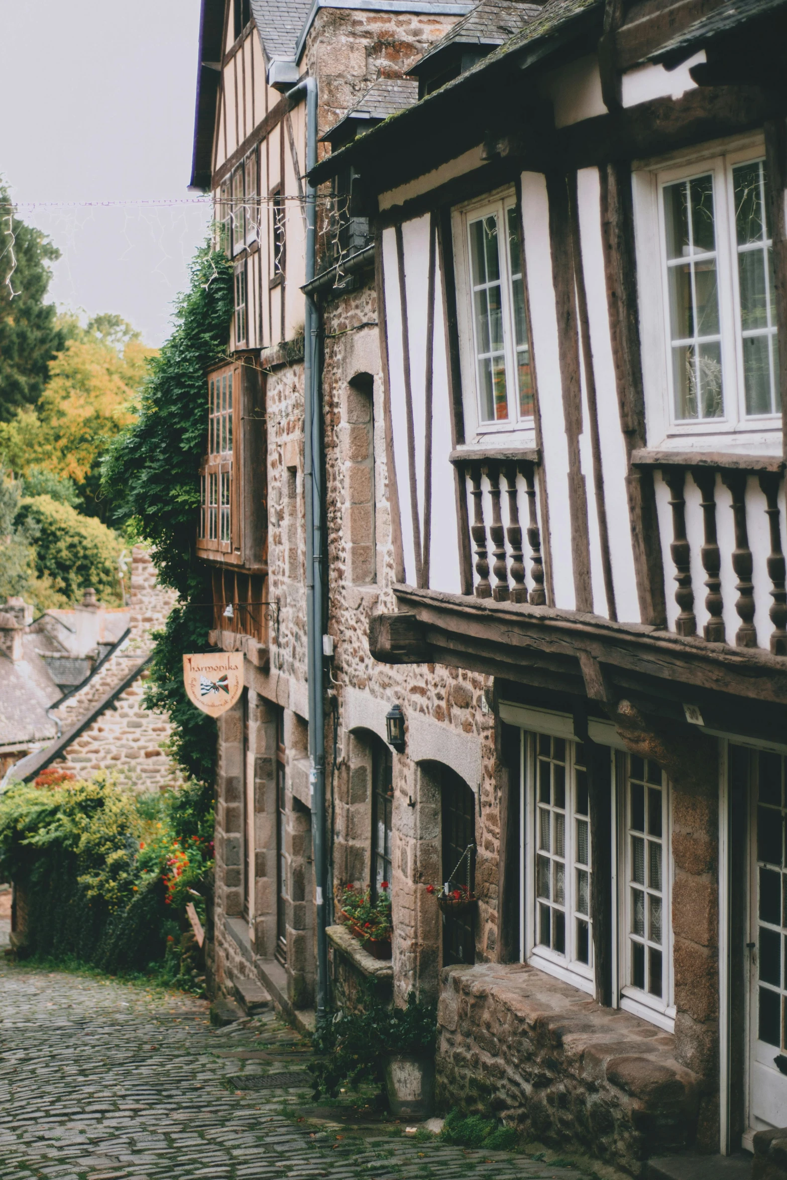 a couple of people walking down a cobblestone street, pexels contest winner, renaissance, log houses built on hills, normandy, gif, balconies