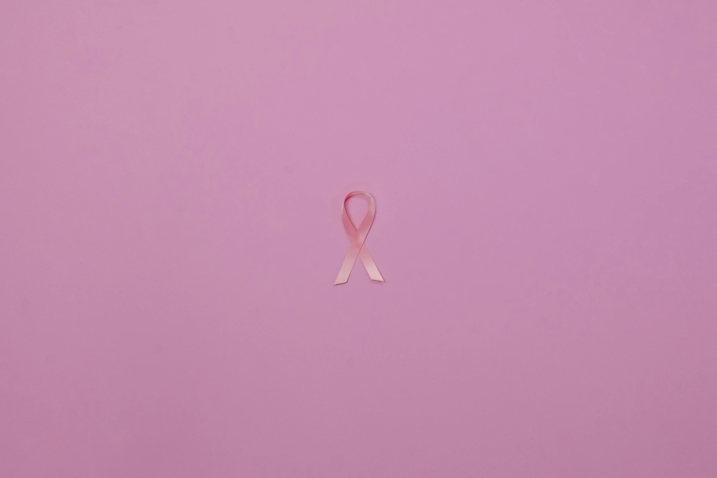 a pink ribbon on a pink background, a picture, by Matija Jama, trending on pexels, light skin, tumours, san francisco, taken in the night