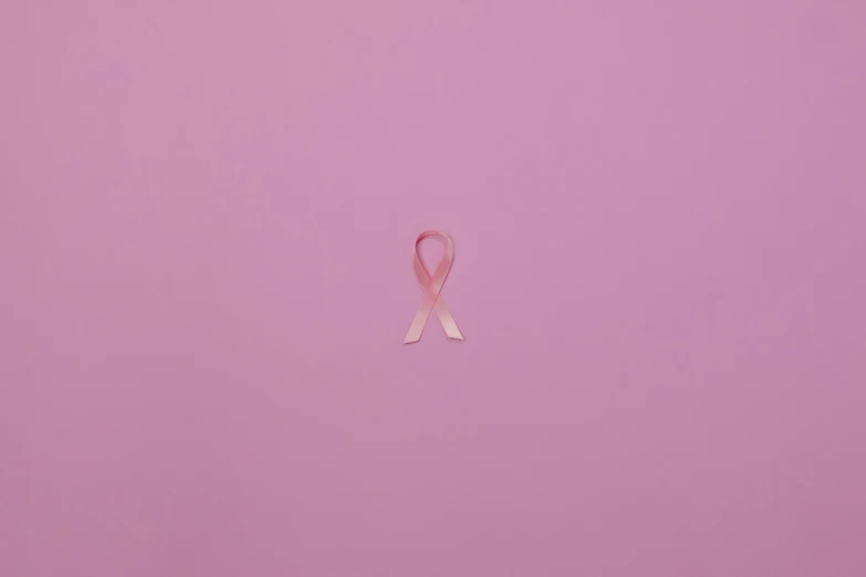 a pink ribbon on a pink background, a picture, by Matija Jama, trending on pexels, light skin, tumours, san francisco, taken in the night