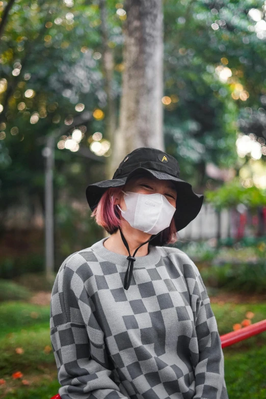 a woman wearing a face mask in a park, trending on pexels, visual art, baggy clothing and hat, discord profile picture, li zixin, black