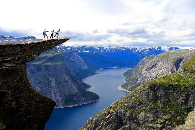 a couple of people standing on top of a cliff, by Tom Wänerstrand, pexels contest winner, hurufiyya, norway mountains, falling off a cliff, facebook post, youtube thumbnail