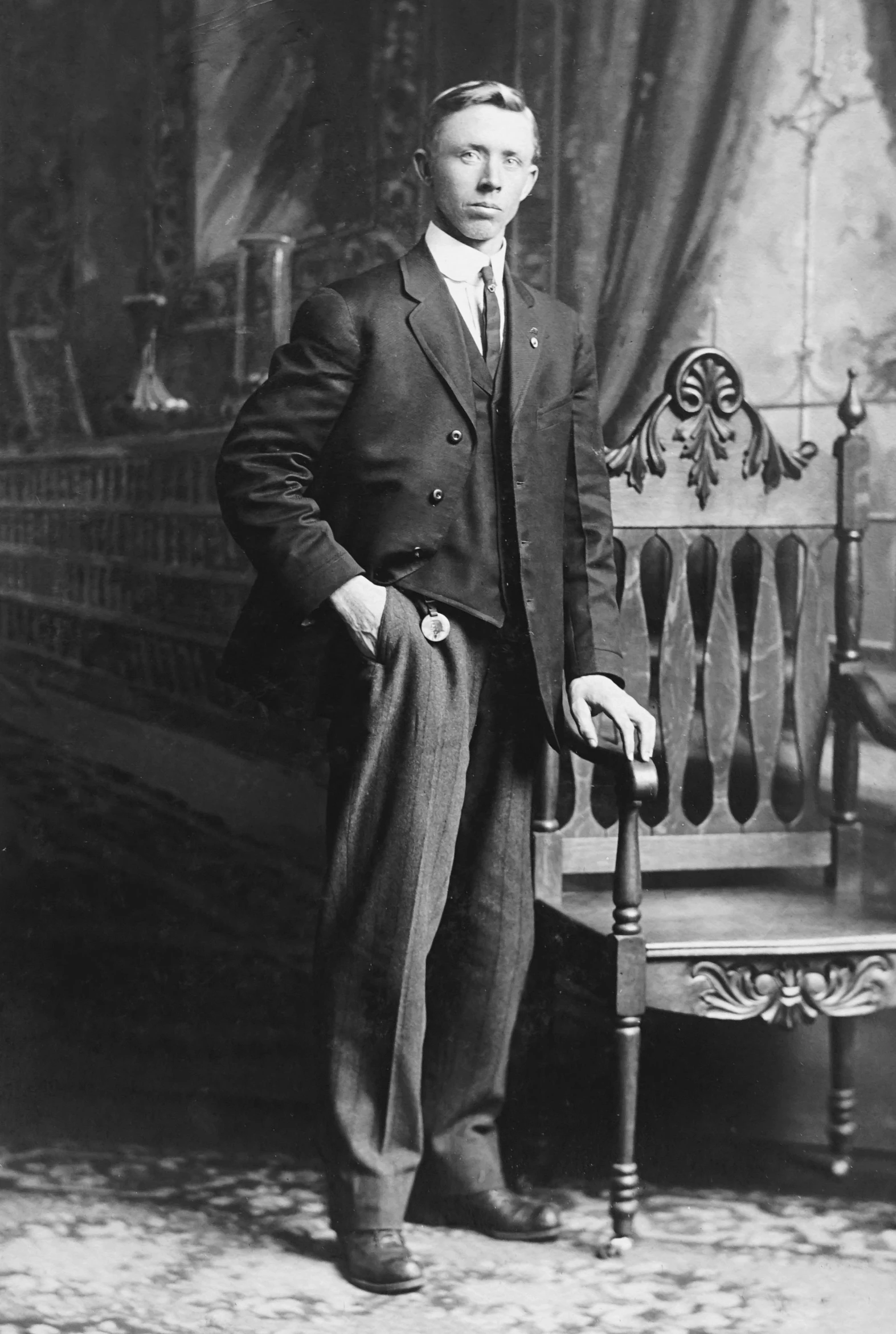 a black and white photo of a man in a suit, inspired by Henry O. Tanner, young man with short, various posed, early 2 0 th century, 1 9 2 0 s furniture