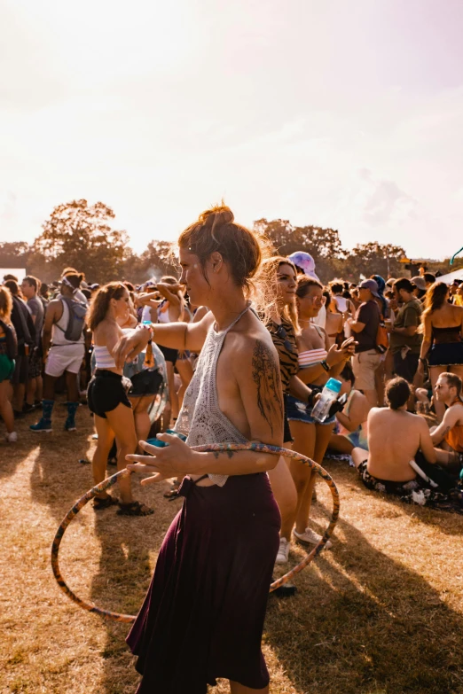 a woman hula hooping in front of a crowd of people, pexels contest winner, sydney park, a person at a music festival, full morning sun, scene from a rave
