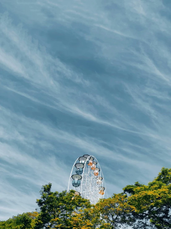 a clock tower sitting on top of a lush green hillside, unsplash contest winner, aestheticism, ferris wheel, giant clouds, sydney park, an enormous silver tree