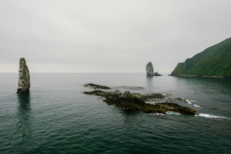 two large rocks in the middle of a body of water, faroe, fan favorite, kakar cheung, high-resolution photo