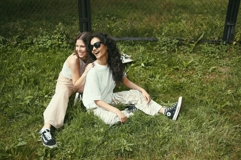 a couple of women sitting on top of a lush green field, woman in streetwear, with white, shohreh aghdashloo, official store photo